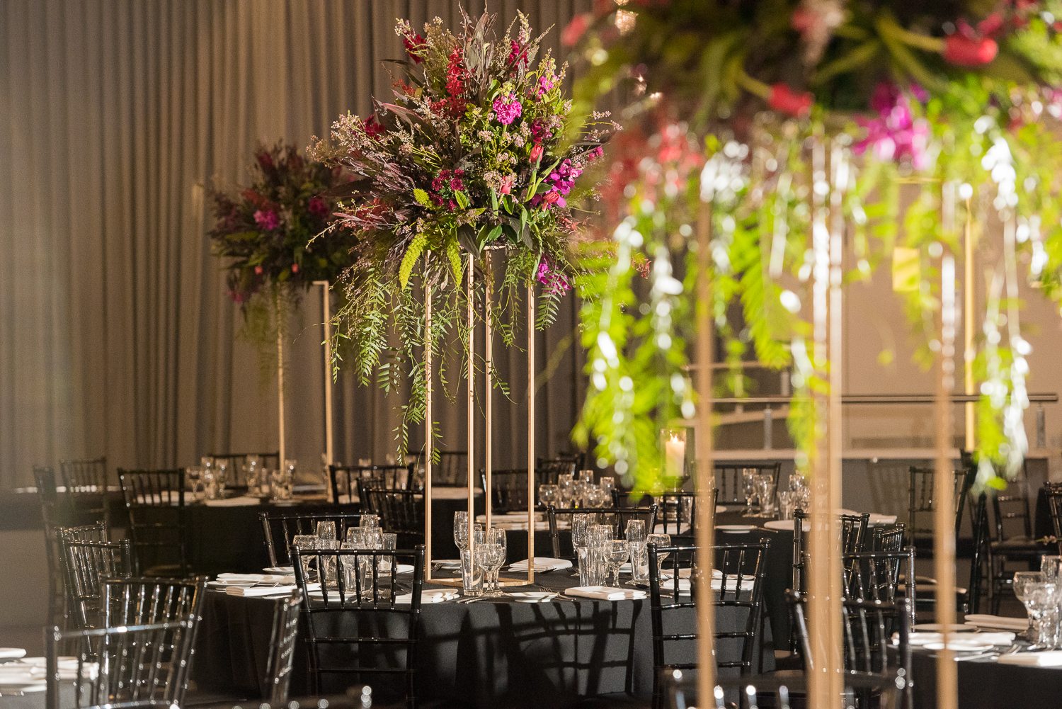 Tall floral arrangement on black draped table