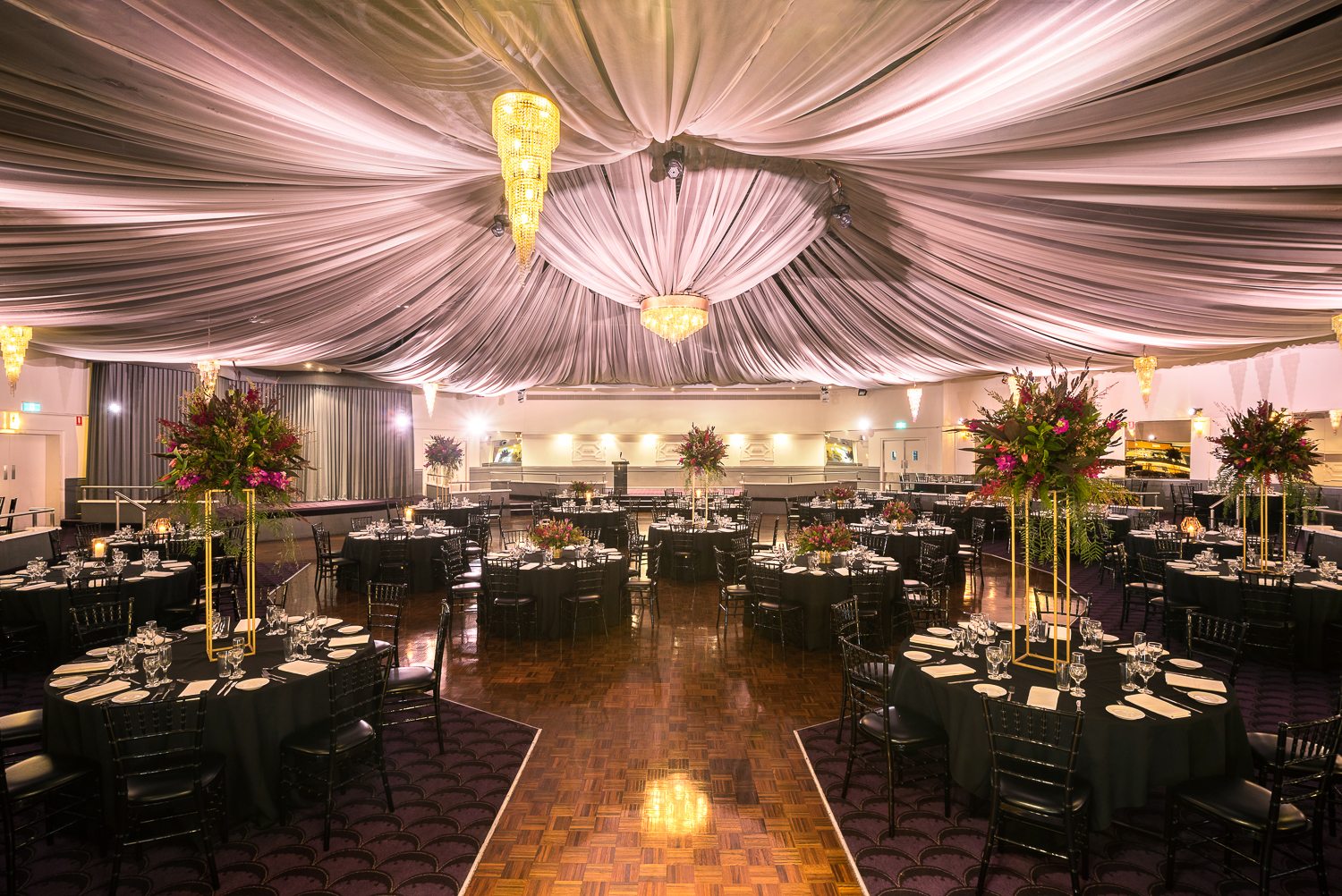 ballroom with mauve canopy, black draped tables and chairs